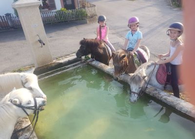 en ballade à poney devant une fontaine