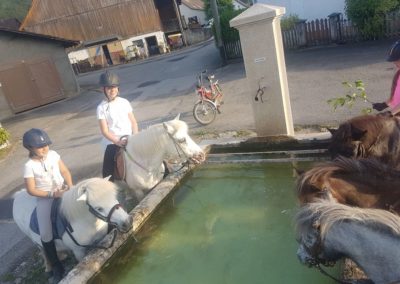 en ballade à poney devant une fontaine